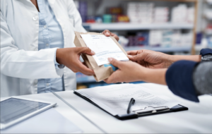 pharmacist handing prescription to patient